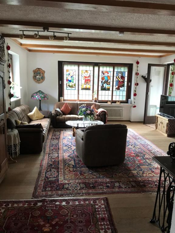Fewo Alpenvorland في بيسينبيرغ: غرفة معيشة مع أرائك ونوافذ زجاجية ملطخة
