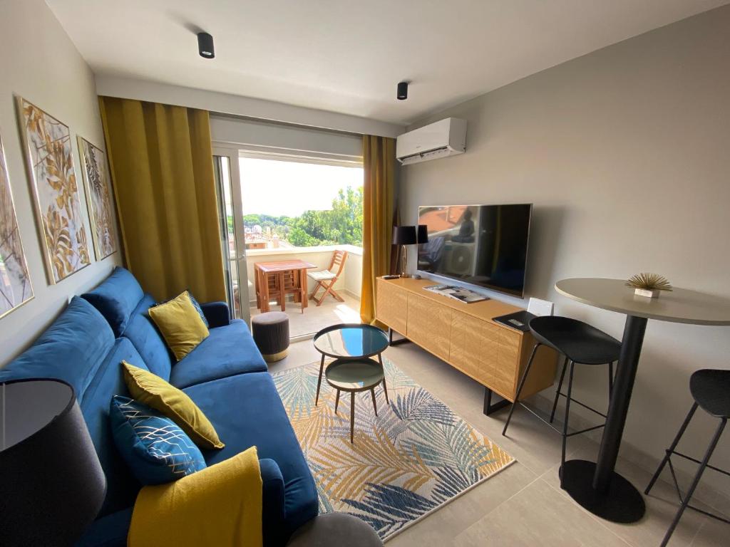 a living room with a blue couch and a tv at Ocean view, Luxury & Relax Dunas de Artola in Marbella