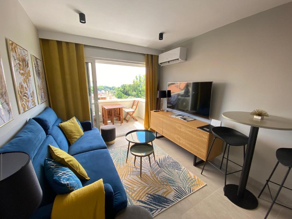 a living room with a blue couch and a tv at Duplex de lujo Marbella- Dunas de Artola in Marbella