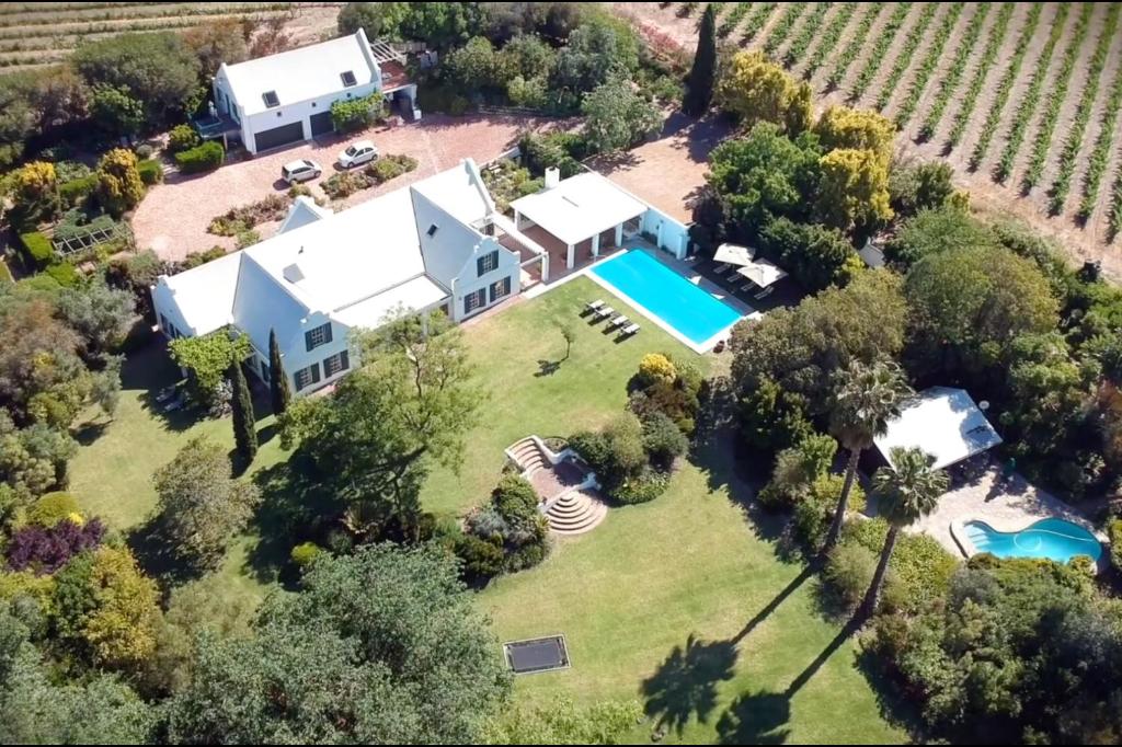 Stellenbosch的住宿－Sanddrif Guest Farm，享有带游泳池的房屋的空中景致