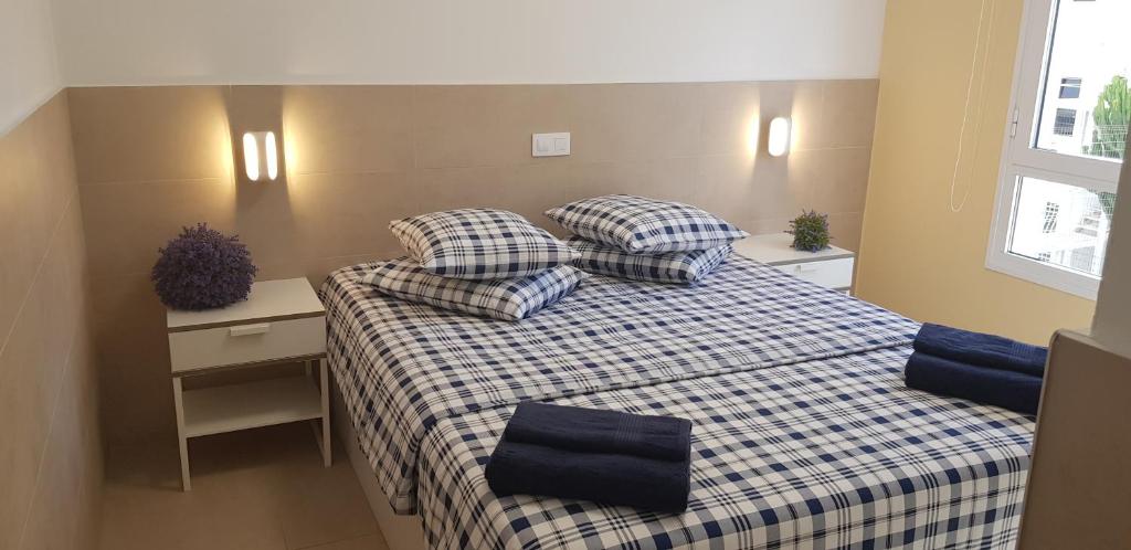 um quarto com uma cama com almofadas em Stylish Apartment em Playa del Inglés