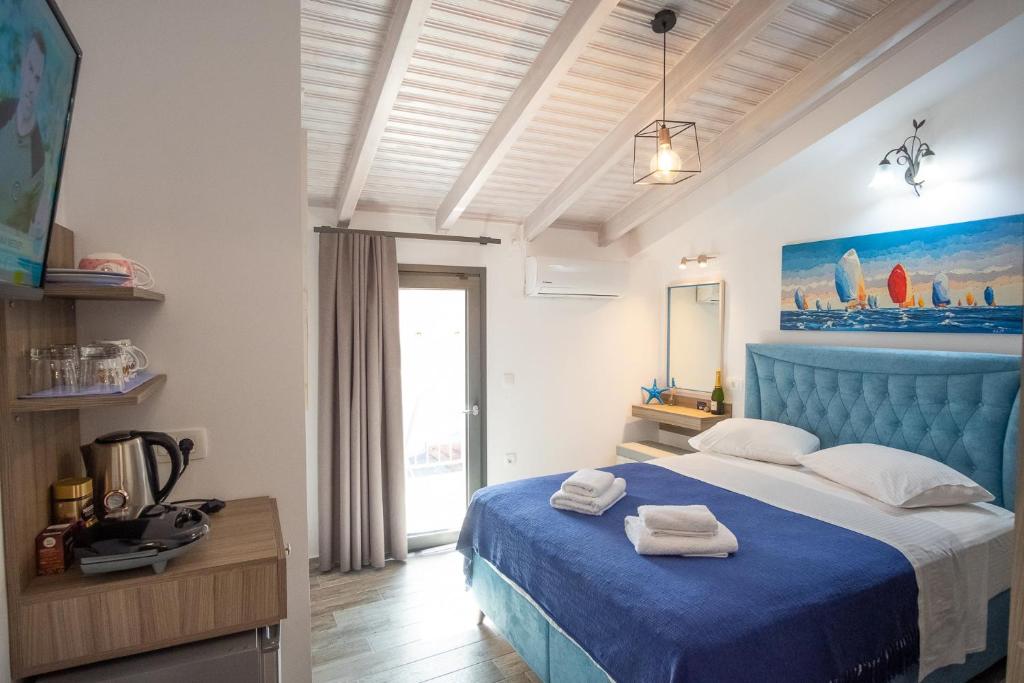 una camera da letto con un letto blu e asciugamani di Serenity Luxe Suites a Párga