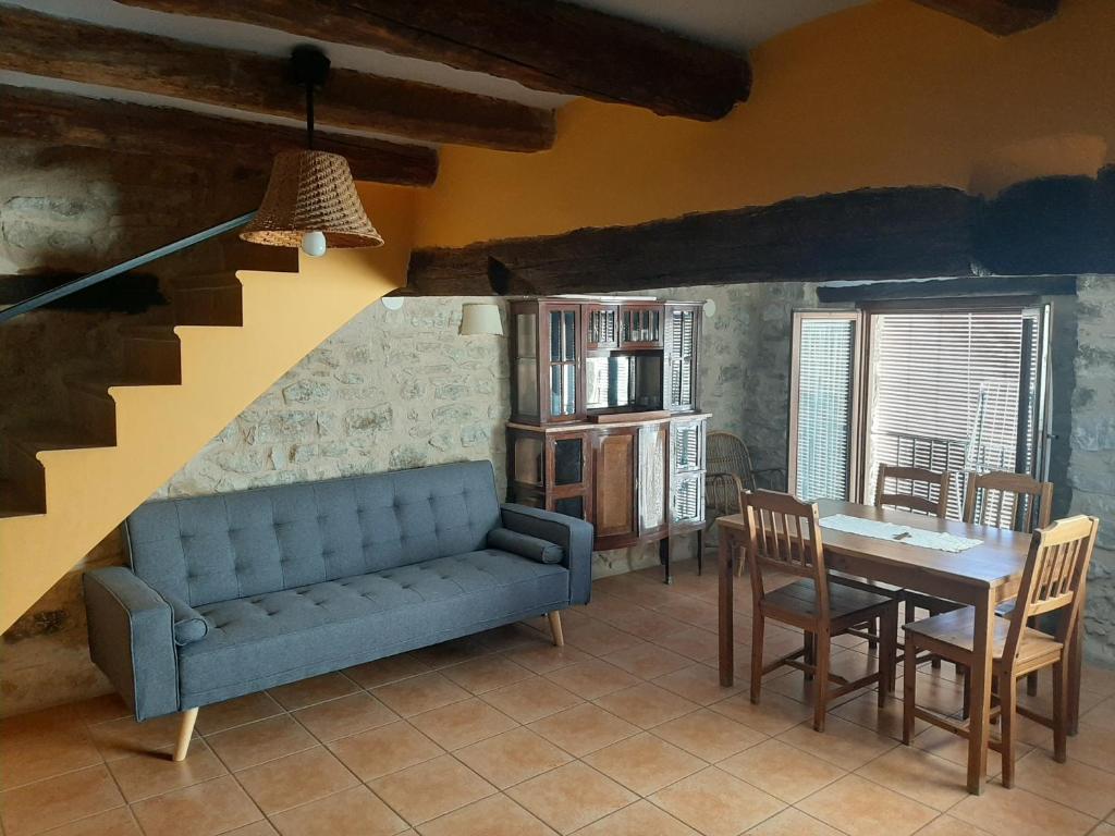 a living room with a blue couch and a table at CASA VICENT in Valderrobres