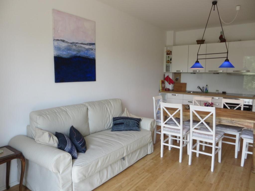 ein Wohnzimmer mit einem weißen Sofa und einer Küche in der Unterkunft Dorothee V6W5 in Dierhagen