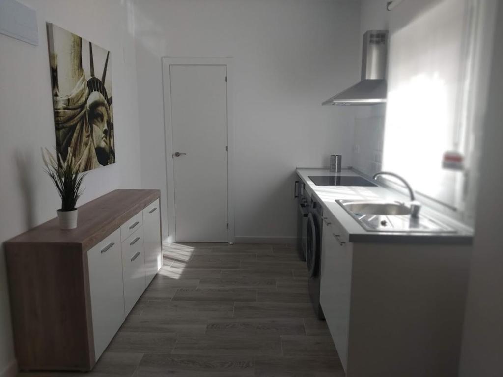 uma cozinha branca com um lavatório e um balcão em Precioso apartamento en San Juan de Alicante em San Juan de Alicante