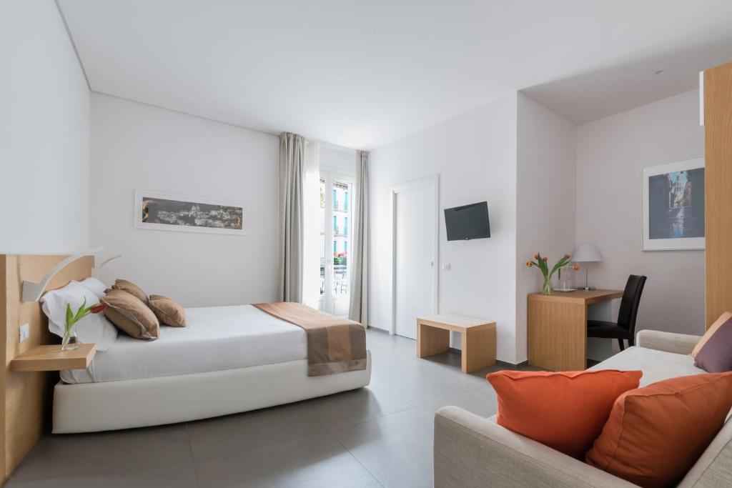 Habitación blanca con cama y sofá en Aurà - Guest House Iblea, en Ragusa