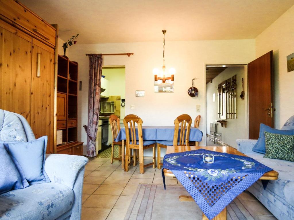 ein Wohnzimmer mit einem Tisch und einem blauen Sofa in der Unterkunft Dorfkoje in Sankt Peter-Ording
