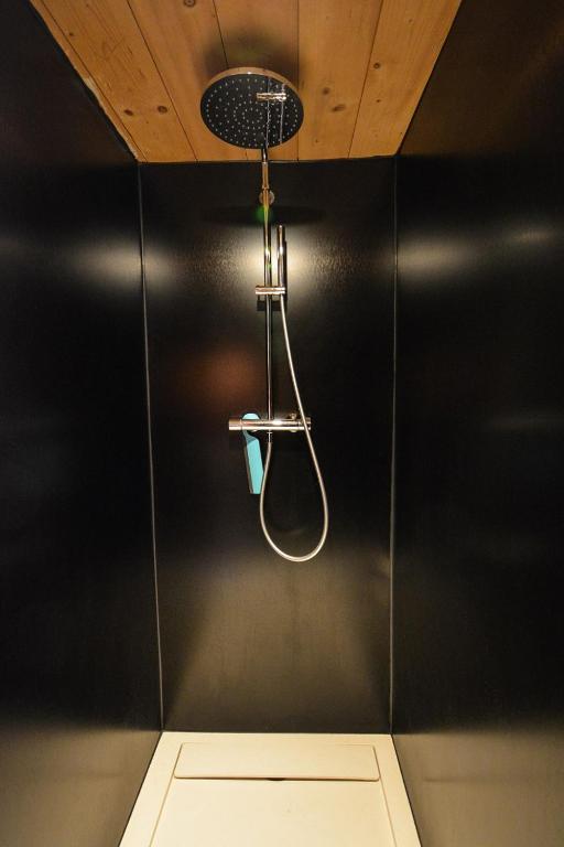 a shower in a bathroom with a black wall at Chalet cosy proche Tramway du Mont-Blanc et centre in Saint-Gervais-les-Bains