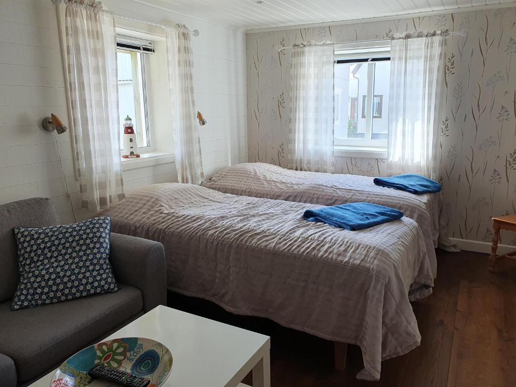 Pokój z 2 łóżkami, kanapą i 2 oknami w obiekcie Nära Smögenbryggan w mieście Smögen