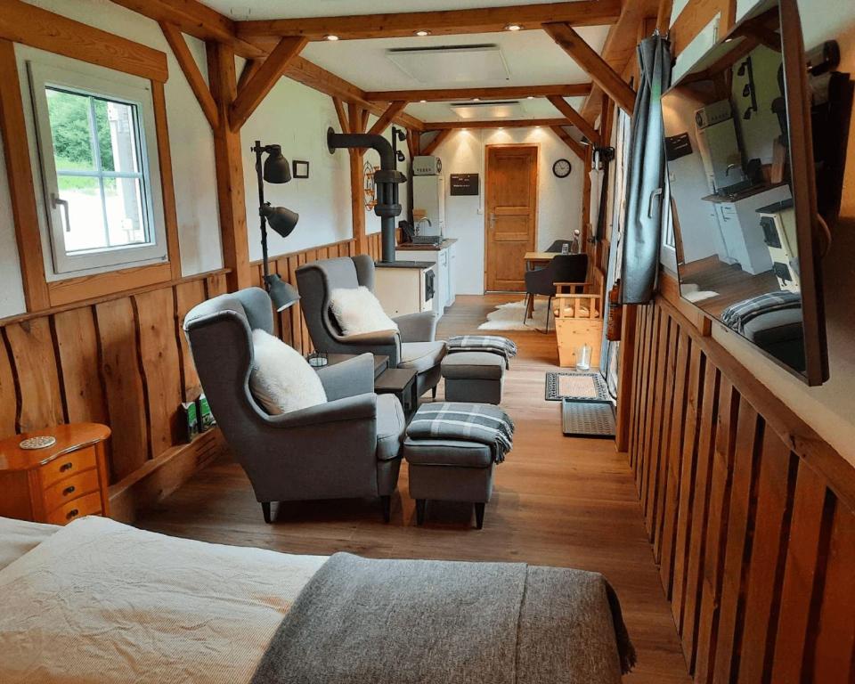 ein Zimmer mit Stühlen und einem TV in einem Haus in der Unterkunft Living Legends - Tiny House auf den Wiesen der Edermühle in Grosspertholz