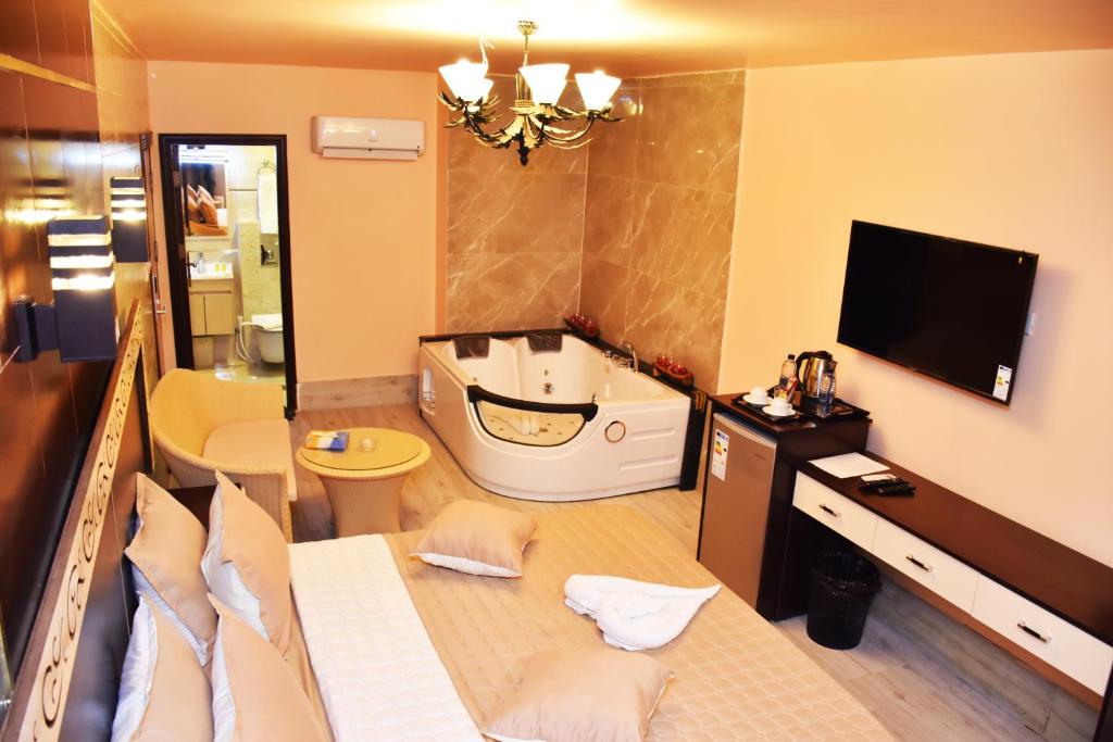 a bathroom with a bath tub and a television in a room at Al-Naher Al-Khaled Hotel in Aqaba