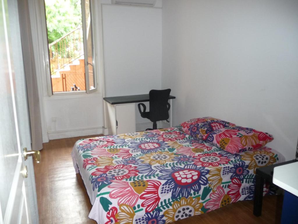 里昂的住宿－Appart-Hotel T1 Lyon8 proche hopitaux，一间卧室配有一张带五颜六色棉被的床