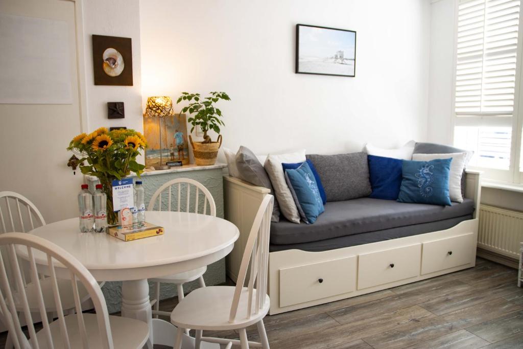 uma sala de estar com um sofá e uma mesa em Hippocampus aan Zee em Katwijk aan Zee