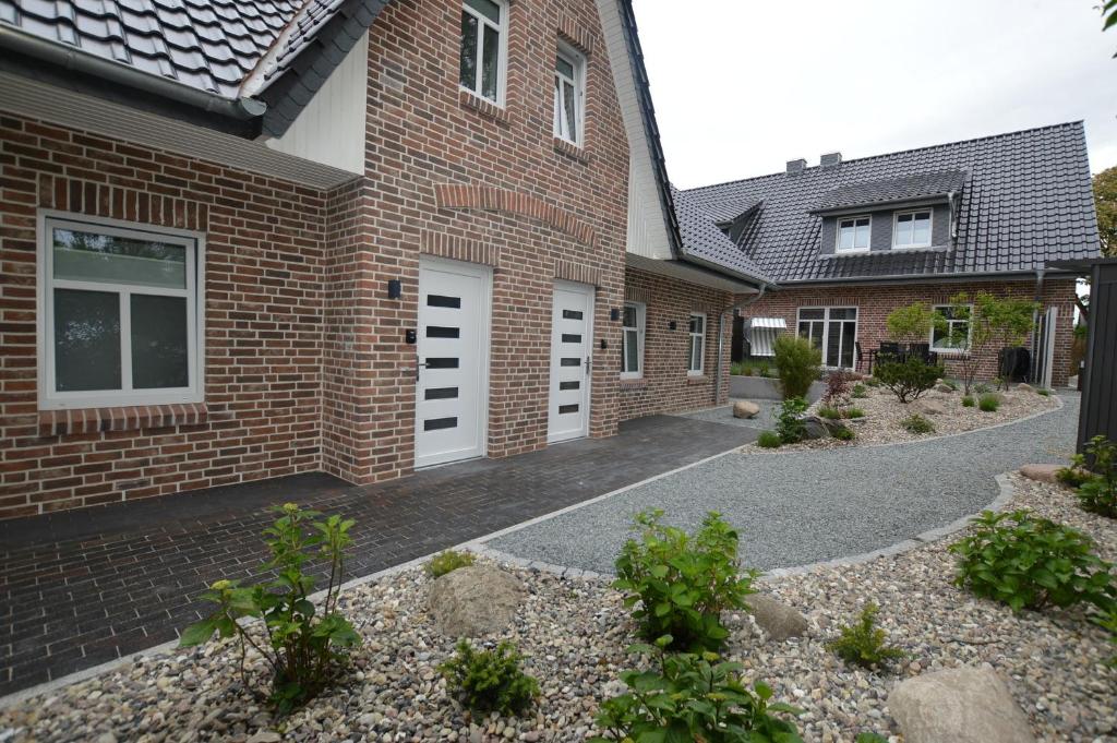 una casa de ladrillo con puertas blancas y entrada en Stadthaus 4, inkl 1 Parkplatz, en Burg auf Fehmarn