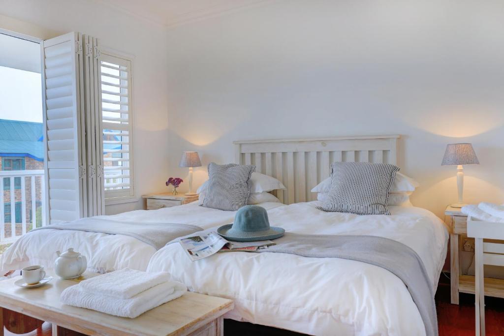 two beds with a hat on top of them in a room at Beach House 11A in Groot Brak Rivier