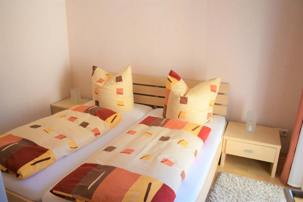 sypialnia z 2 łóżkami i kolorowymi poduszkami w obiekcie Ferienwohnung Borken w mieście Bad Salzungen