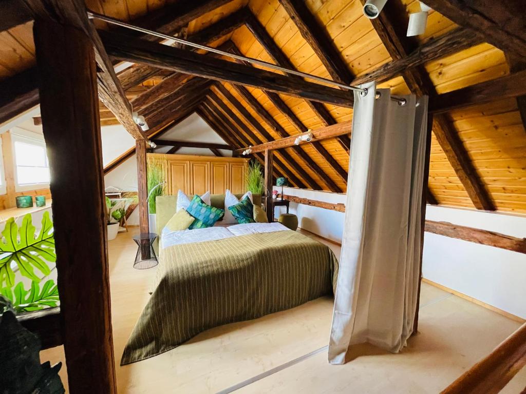 een slaapkamer met een bed in een kamer met houten plafonds bij Ferienhaus Zur Hofreite in Mainz