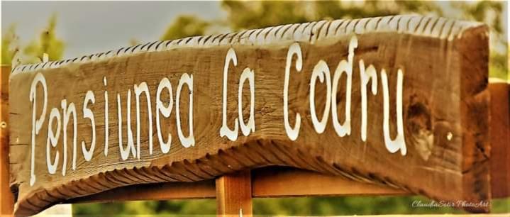 a wooden bench with writing on the top of it at Pensiunea La Codru in Jurilovca
