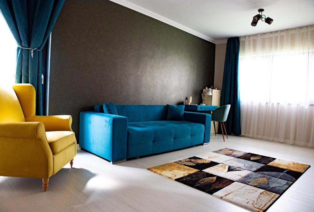 sala de estar con sofá azul y silla amarilla en La Stejari Apartment en Suceava