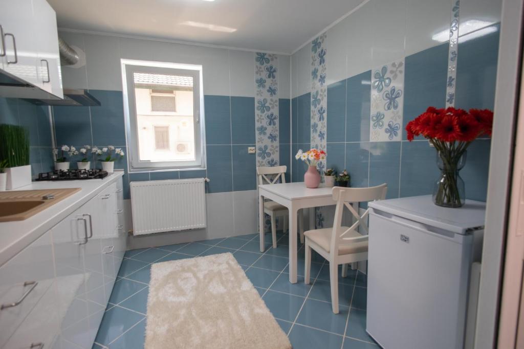 a blue and white kitchen with a table and chairs at Aquarium Apartment in Buzău