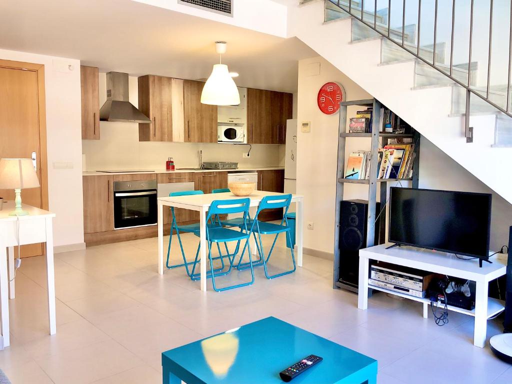 cocina y sala de estar con mesa y TV en Duplex RIO EBRO, en Deltebre