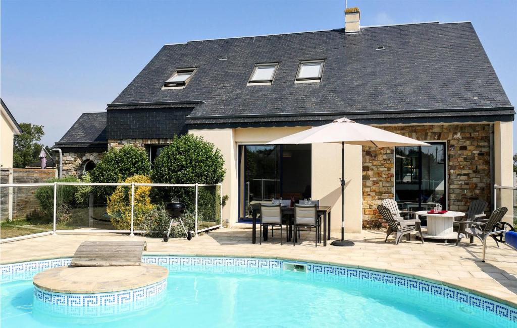 a house with a swimming pool with a table and an umbrella at Gorgeous Home In Saint-Germain-Sur-Ay in Saint-Germain-sur-Ay