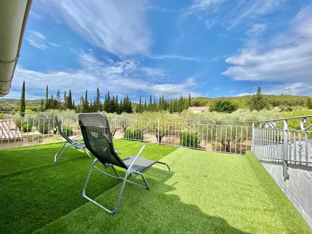 - deux chaises assises sur une pelouse sur un balcon dans l'établissement Il y a le Soleil, la Campagne et la Mer, à Martigues