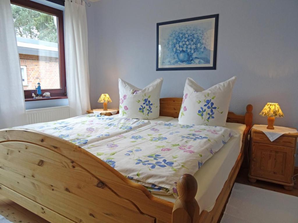 a bedroom with a large wooden bed with pillows at Haus Doris Whg 1 in Nienhagen