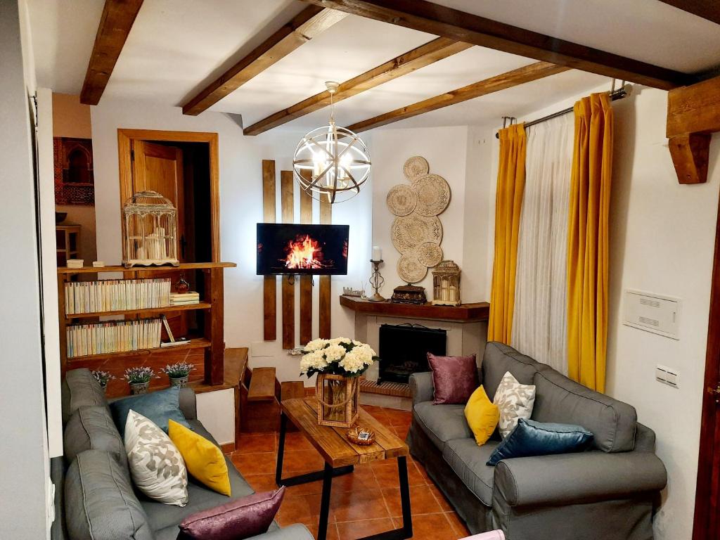 sala de estar con 2 sofás y chimenea en Mi rinconcito en Sierra de Grazalema en Benaocaz