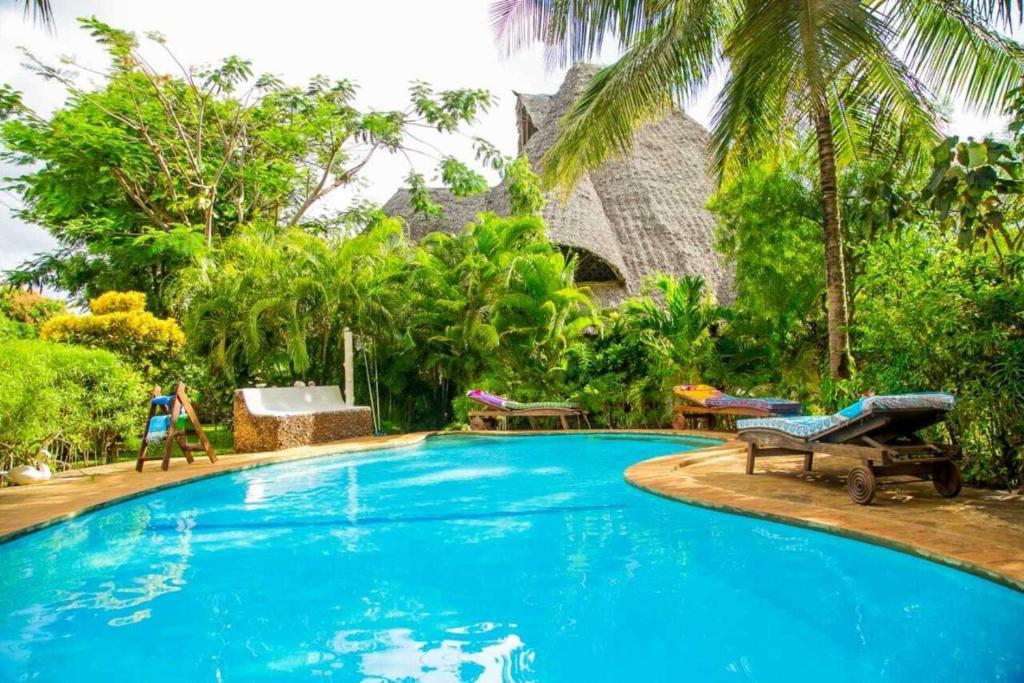 a large blue swimming pool in a resort at 3 Bed Cottage Sleeps 6- Pool Chef Option Parking in Diani Beach
