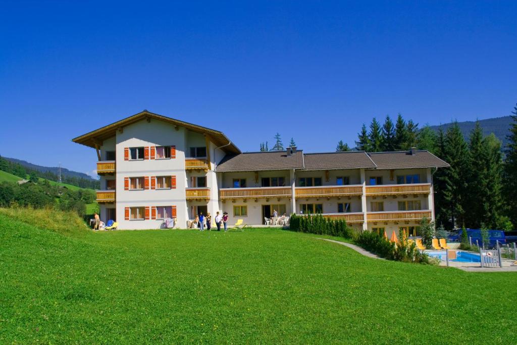 ein großes Gebäude auf einem grünen Hügel in der Unterkunft Appartmentanlage Isegrim in Altenmarkt im Pongau