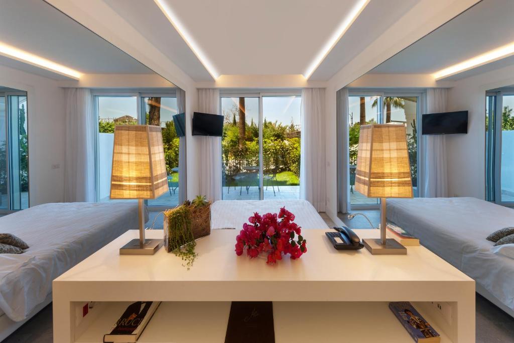 a bedroom with two beds and a table with flowers at Hotel Alpha in Sant'Agnello