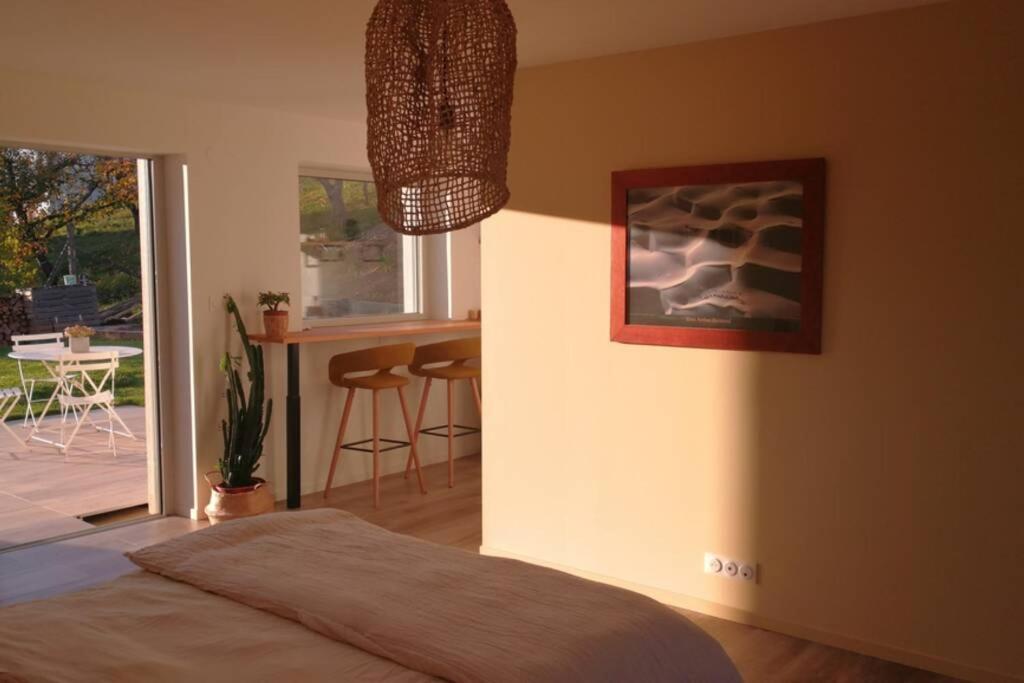 a bedroom with a bed and a table with chairs at Parenthèse nature in Soultz-Haut-Rhin