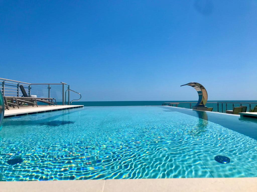 a swimming pool with a view of the ocean at Park Hotel Pineta & Dependance Suite in Eraclea Mare