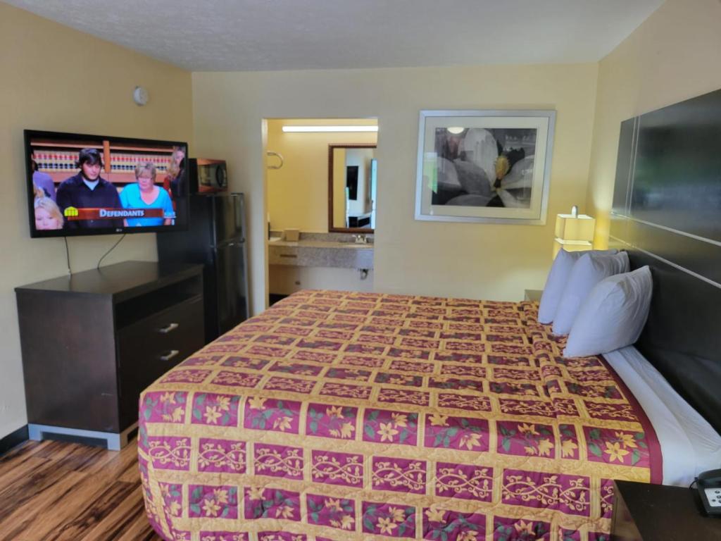 カータースビルにあるCountry Hearth Inn & Suites Cartersvilleのベッド1台、薄型テレビが備わるホテルルームです。