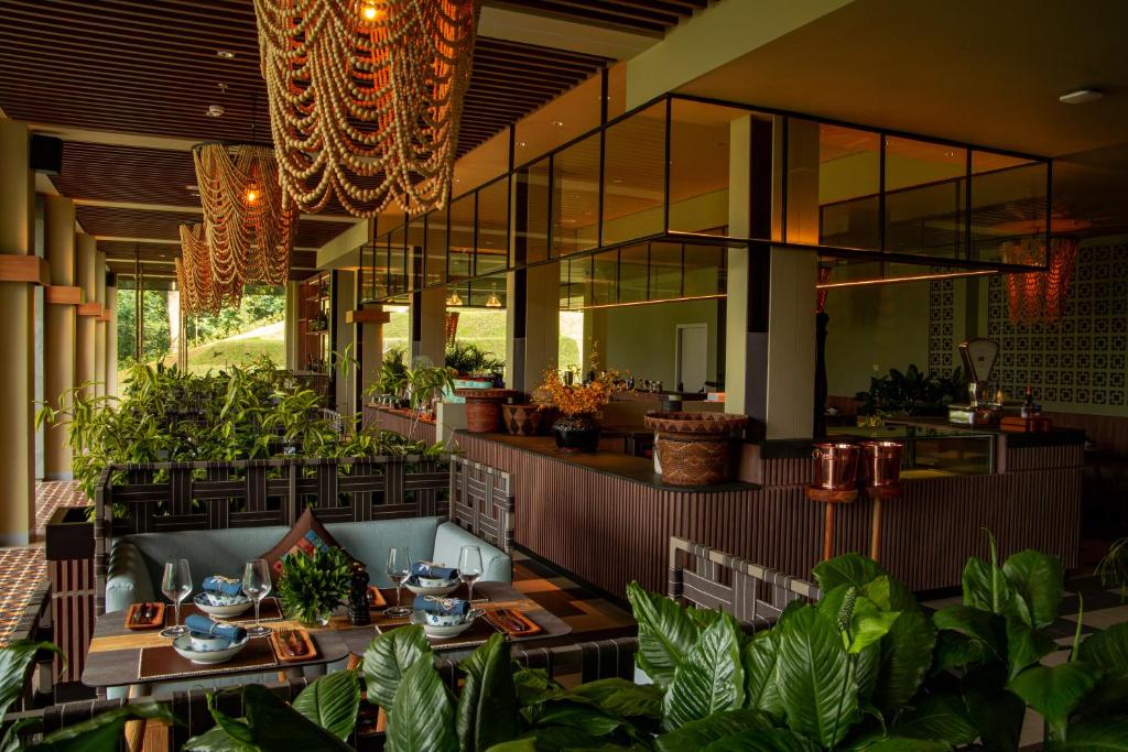 a restaurant with tables and plants in a room at The Botanica Sanctuary in Puncak