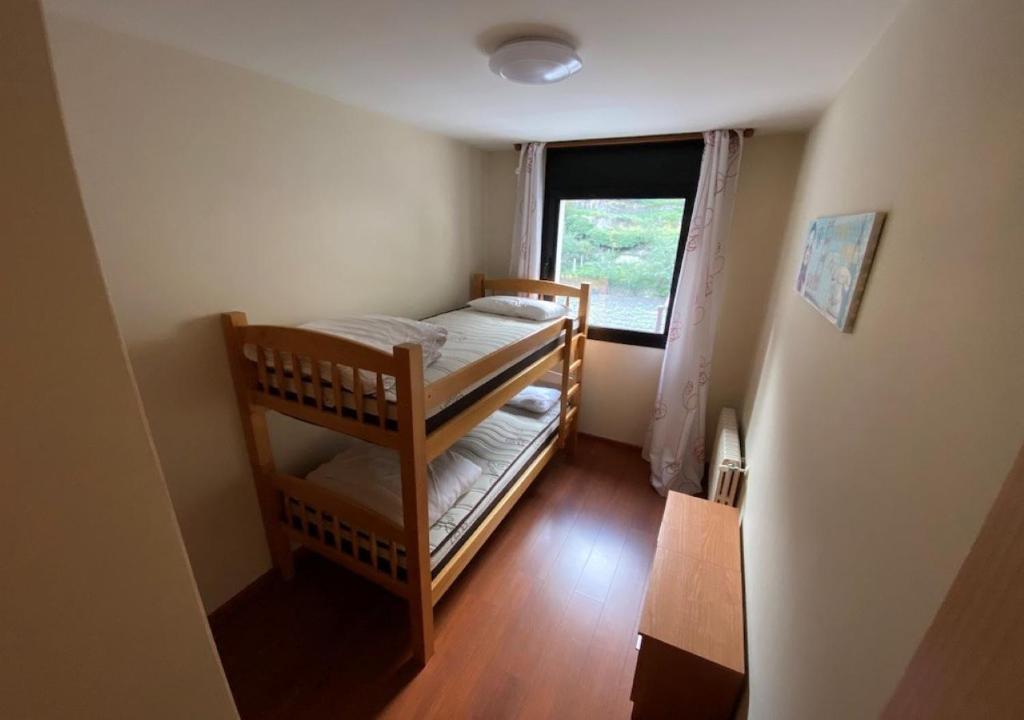 Cette chambre comprend 2 lits superposés et une fenêtre. dans l'établissement Apartament l'Areny 21 - 6p - Canillo - Zona Grandvalira, à Canillo