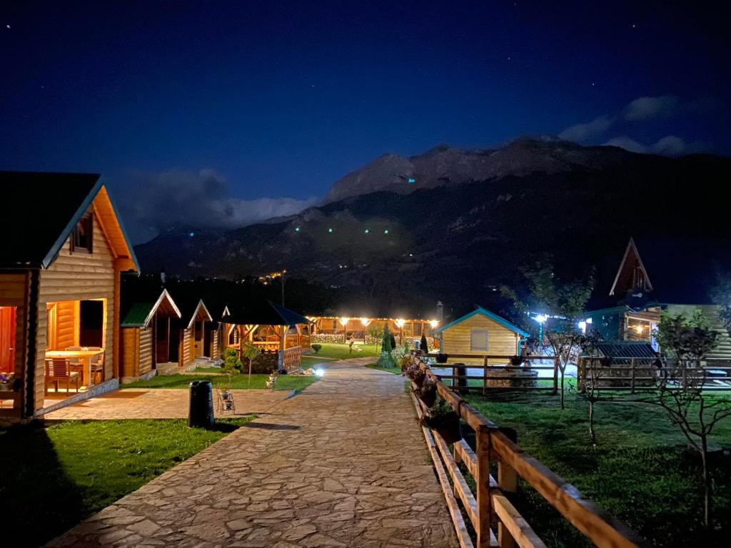 een dorp 's nachts met een berg op de achtergrond bij Ethno House Bektesevic in Gusinje