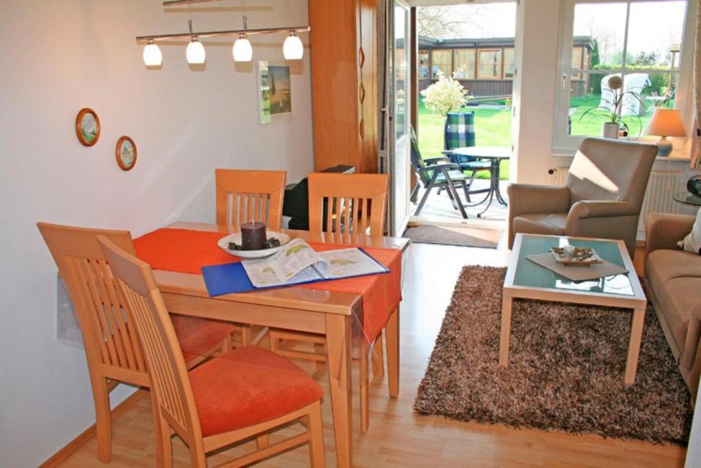 a dining room and living room with a table and chairs at "Landhaus Voss" Typ 1 Nr2 in Staberdorf