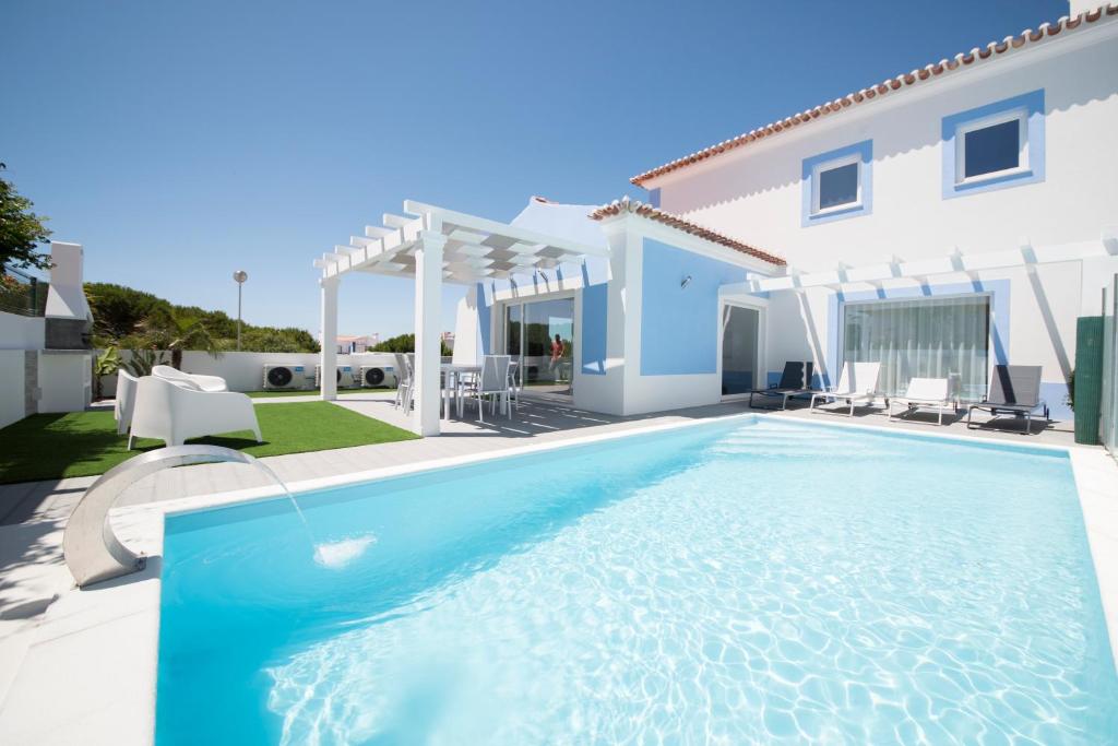 a swimming pool in front of a villa at Casa Lusitana da Praia & Casa Lusitana Mare Alta in Porto Covo