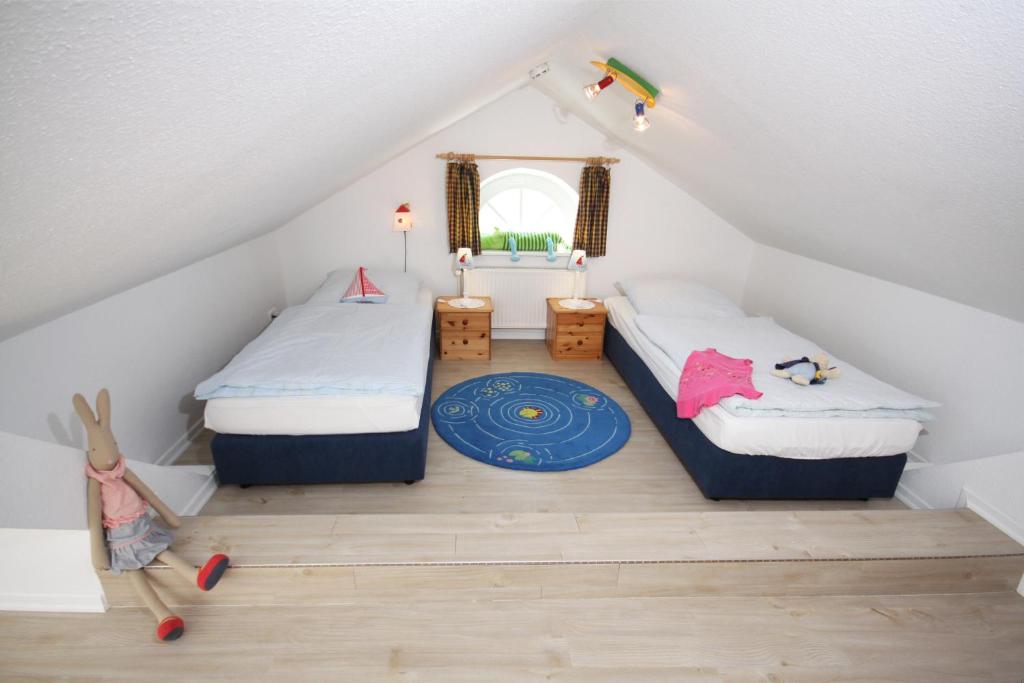 a attic bedroom with two beds and a rug at "Ferienhof Sporleder" - Landhaus Nr1 in Meeschendorf