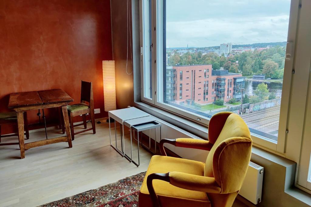 a room with a large window with a chair and a desk at The Cutest Studio in Central Tampere in Tampere