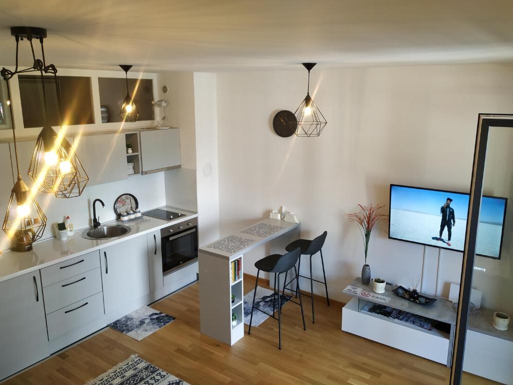 Bulevar apartment & Free Garage في سراييفو: مطبخ مع مكتب وتلفزيون على الحائط
