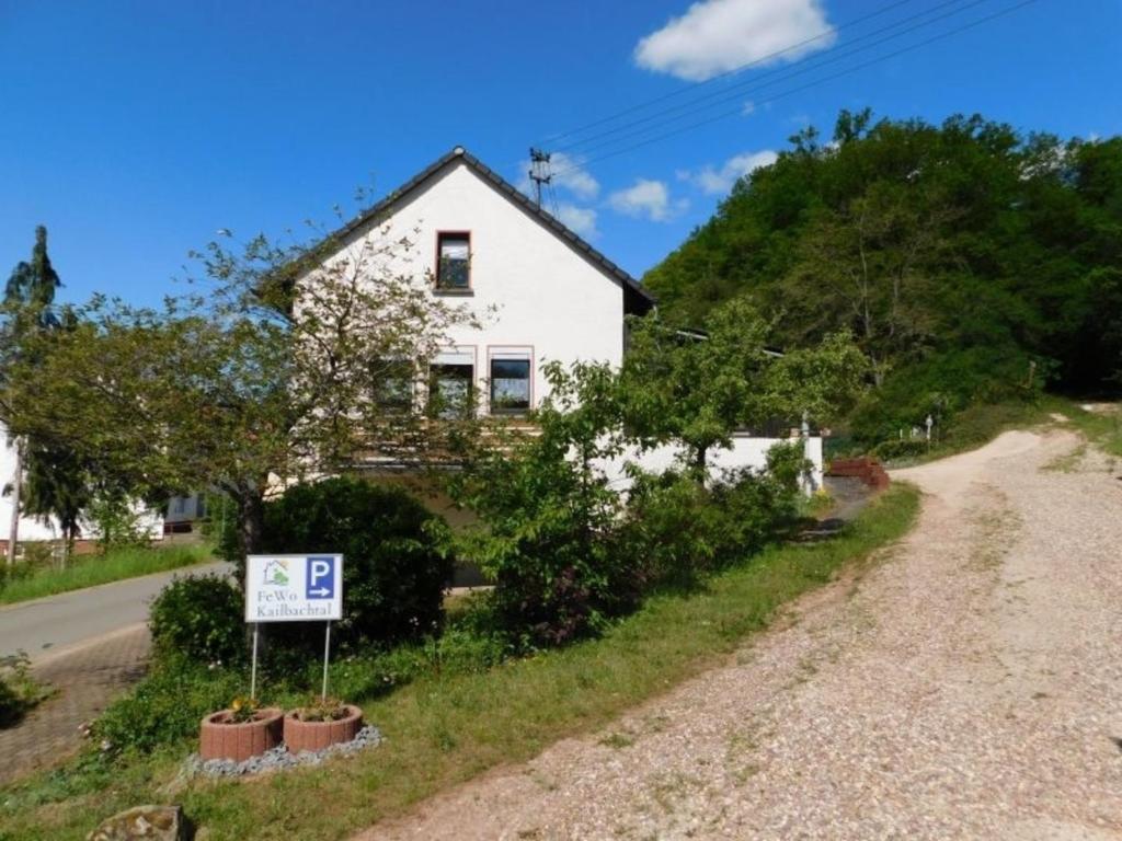 uma casa numa colina com um sinal em frente em FeWo Kailbachtal em Landscheid