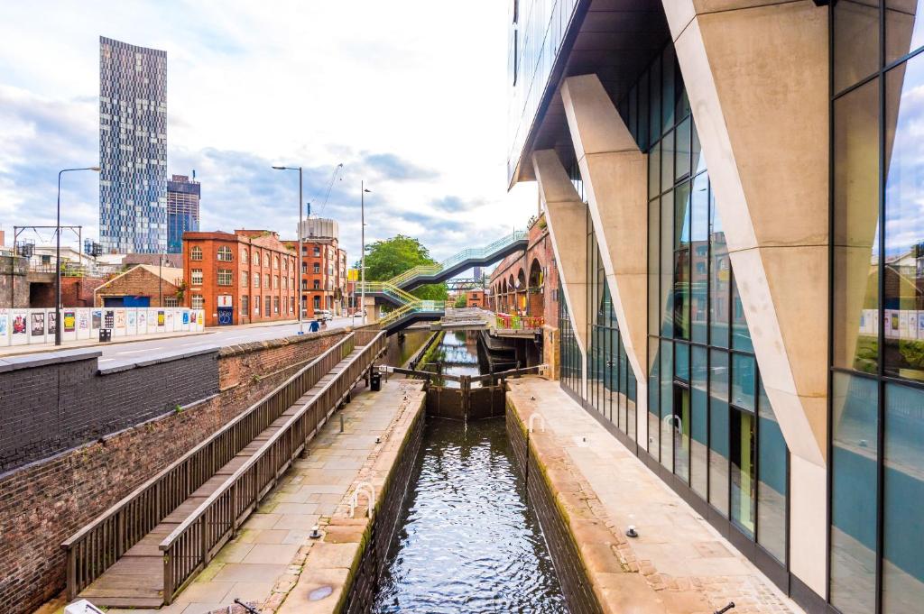 a canal in the middle of a city with buildings at Hilltop Serviced Apartments - Deansgate in Manchester