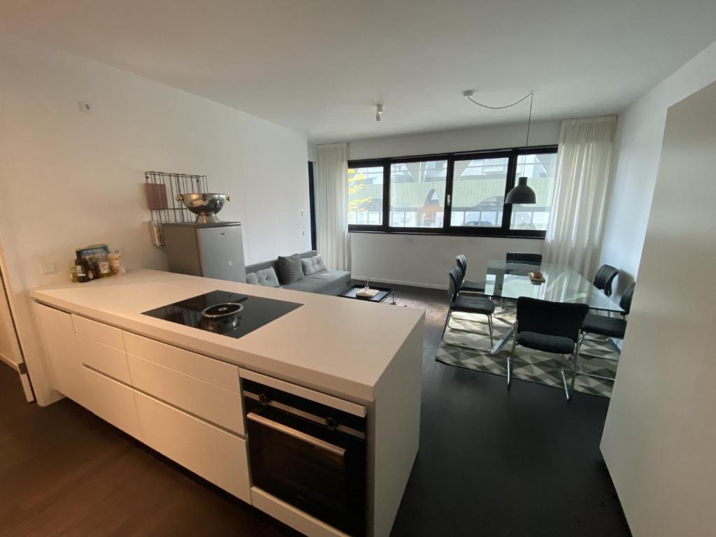 Friedrichshain Apartment في برلين: مطبخ وغرفة معيشة مع طاولة وكراسي