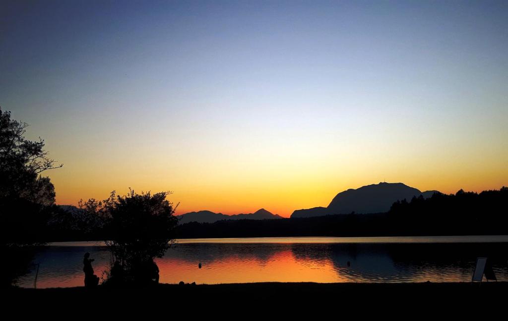zachód słońca nad jeziorem z górami w tle w obiekcie Dingsbums w mieście Unteraichwald