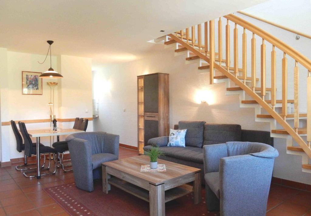 a living room with a couch and a table and stairs at Ferienparadies Rugana D07 in Kreptitz