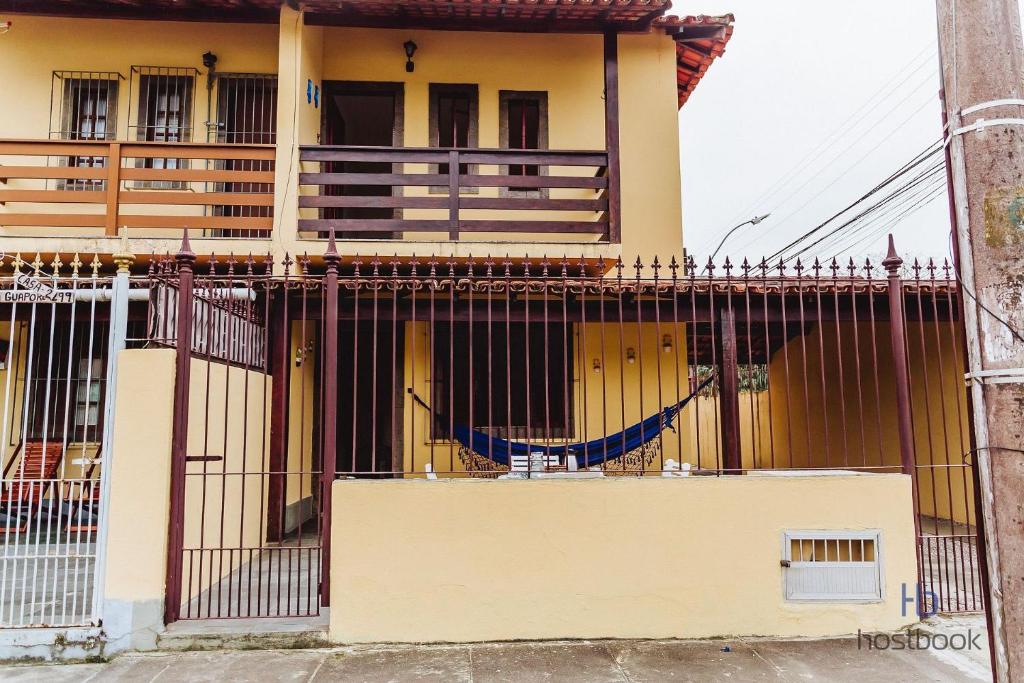a house with a fence in front of it at Casa a 300 metros da praia do Centro - WIFI 200MB - TV Smart - 2 Quartos - Cozinha equipada - Churrasqueira - Pet friendly - Quintal in Rio das Ostras