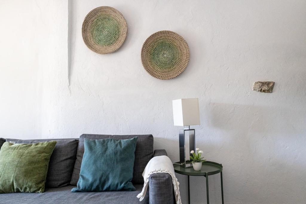 ein Wohnzimmer mit einem Sofa mit Kissen und einer Lampe in der Unterkunft Casa de Santa Maria in Castelo de Vide